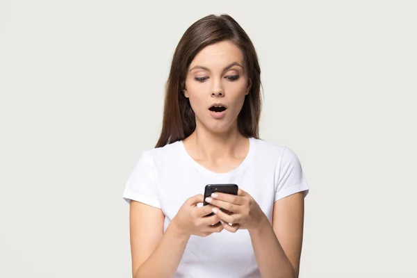 Szoku dziewczyna trzymając telefon uczucie oszołomiony o nieoczekiwanych wiadomość na telefon komórkowy — Zdjęcie stockowe