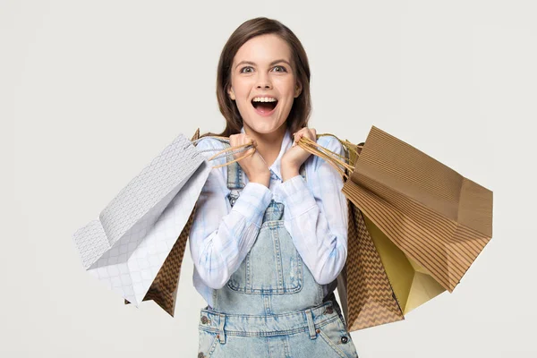 Excited girl holding paper bags enjoy sale isolated on background — Stock Photo, Image