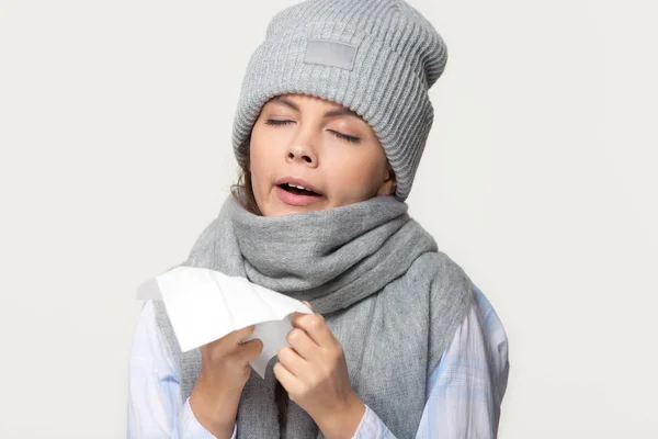 Mulher doente no inverno cachecol e chapéu segurando lenço espirros — Fotografia de Stock