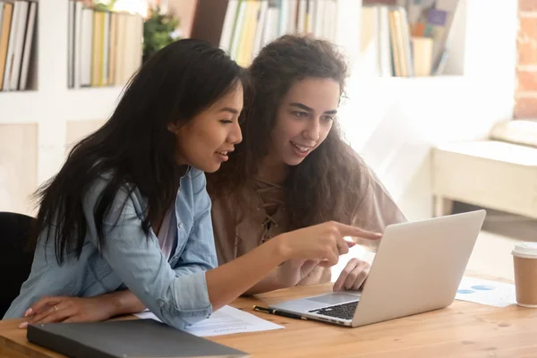 Jovens estudantes diversos trabalhadores falando no escritório olhando para laptop — Fotografia de Stock