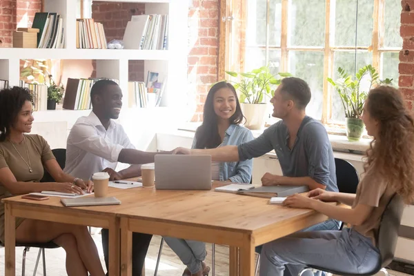 Empresarios africanos y caucásicos se dan la mano en reunión de grupo — Foto de Stock