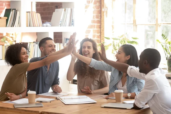 Feliz equipo de negocios multiétnicos unir las manos dando cinco altos — Foto de Stock