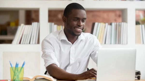 コンピューターでアプリ研究オンラインを使用して幸せ黒人男性学生 — ストック写真
