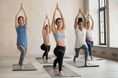 Bir grup genç insan yoga dersi, Warrior egzersiz pratik