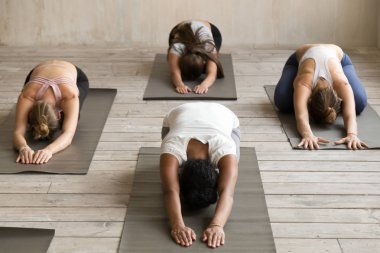 Bir grup insan yoga dersi, pratik çocuk poz, Balasana yapıyor