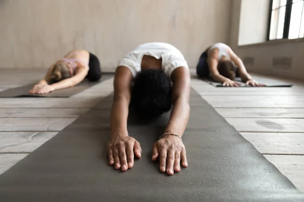 Mulher yogi preto e grupo de pessoas fazendo exercício Balasana — Fotografia de Stock