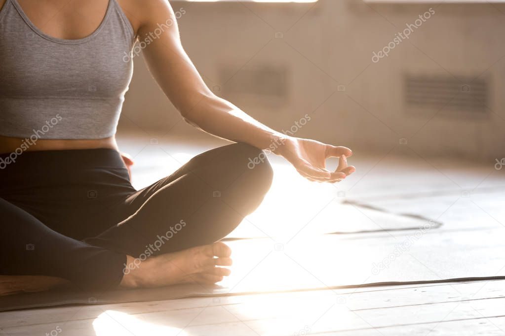 Young sporty yogi woman practicing yoga, doing Easy Seat exercise