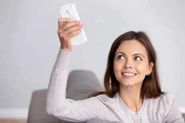 Sorridente giovane donna utilizzando il telecomando del condizionatore d'aria da vicino — Foto Stock