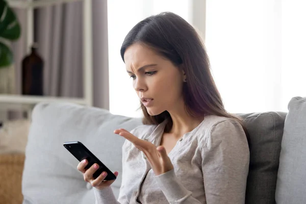 Upset young woman having problem with mobile phone, reading bad news — Stock Photo, Image