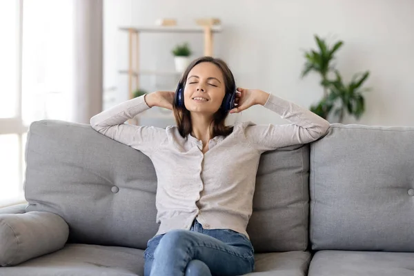 Smiling woman in headphones enjoying music with closed eyes — Stock Photo, Image