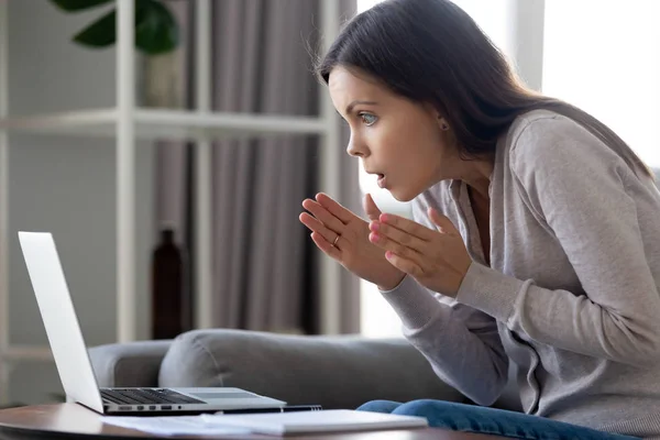 Terkejut menarik wanita melihat dengan takjub pada layar laptop — Stok Foto