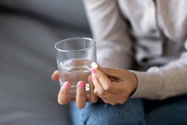 Cerrar mujer enferma sosteniendo el vaso con agua y píldora en las manos — Foto de Stock