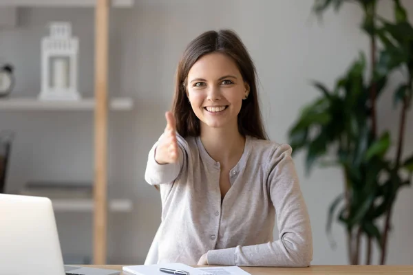 Head shot portrait of smiling woman with extended hand at camera — Stock Photo, Image