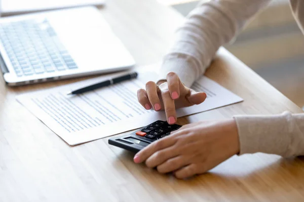 Primer plano mujer joven usando calculadora, cálculo de las finanzas en el lugar de trabajo — Foto de Stock