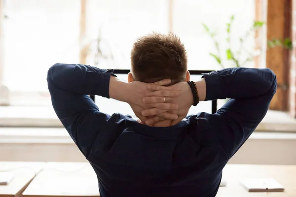 Vista trasera hombre de negocios sentado en la silla poner las manos detrás de la cabeza — Foto de Stock