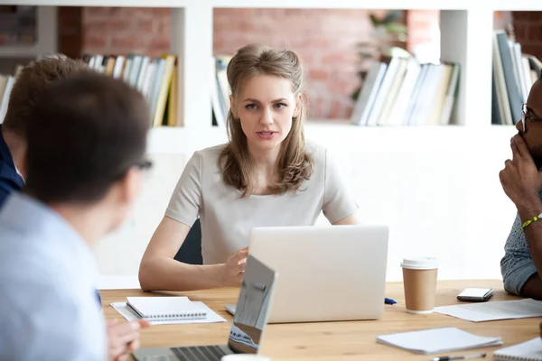 Jefe serio mujer discutiendo proyecto con los empleados sentados en la oficina — Foto de Stock