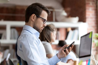 Smartphone aygıt ekranına bakarak tutan işadamı odaklı