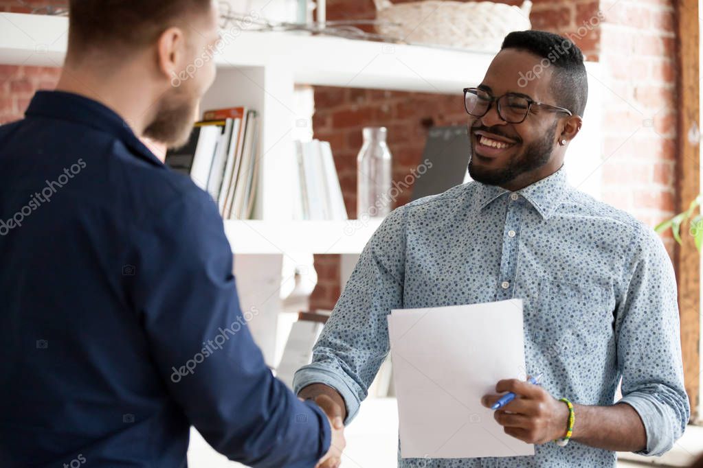 Black executive manager greeting company client starting business meeting