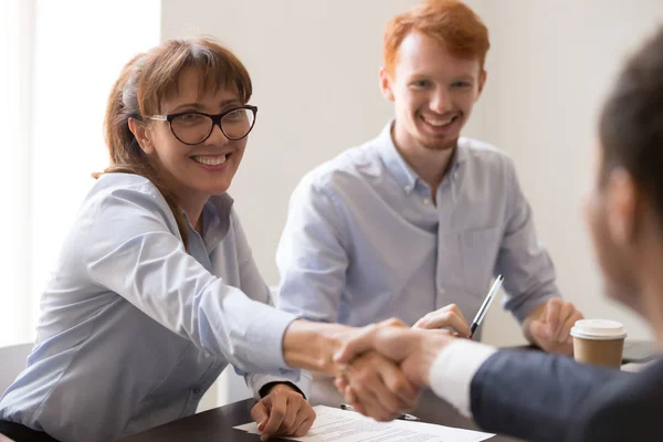 Sonriente mujer de mediana edad hr gerente apretón de manos contratación masculina solicitante — Foto de Stock