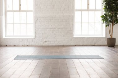 Boş odada doğal ahşap zemin üzerinde Yoga mat