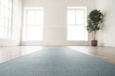 Boş odada katta unrolled yoga mat kapatın