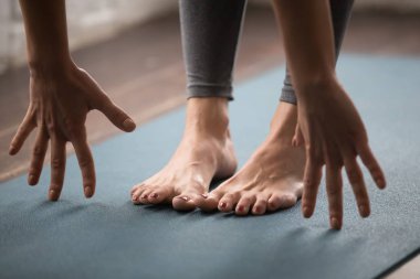 Uttanasana kadın pratik yoga, poz vermek, diz kafasına yakın çekim