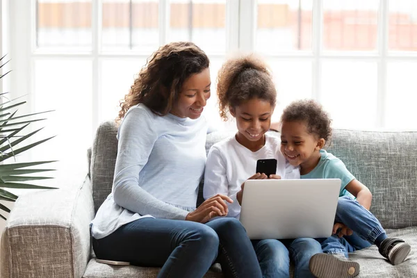 Maman noire s'amuser avec des enfants en utilisant des gadgets à la maison — Photo