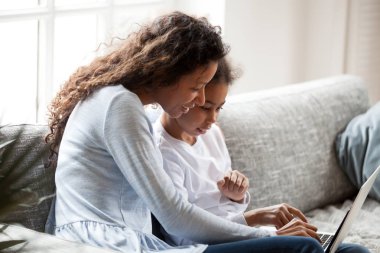 Genç anne ve küçük kızı dizüstü birlikte kullanma