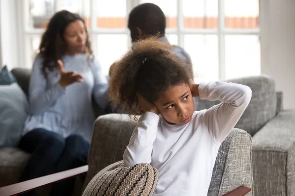 Molesto pequeña chica negra cubre oídos evitando conflicto familiar — Foto de Stock