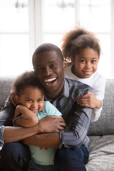 Retrato de papá negro feliz divertirse abrazando a los niños — Foto de Stock