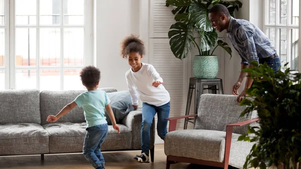 Papa noir excité jouer jeu drôle avec des enfants à la maison — Photo