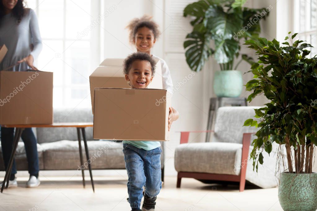 Excited small black kids with boxes happy to move in