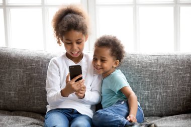 Komik küçük siyah çocuklar smartphone üzerinde oynarken iyi eğlenceler