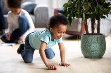 Komik küçük siyah yürümeye başlayan çocuk oynamak oyuncak araba ile