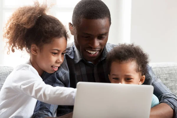 Souriant jeune papa noir jouer sur ordinateur portable avec des enfants — Photo