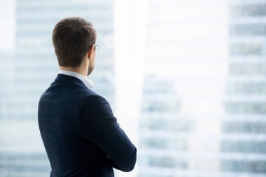 Arkadan görünüş işadamı pencereden bakarak takım ayakta