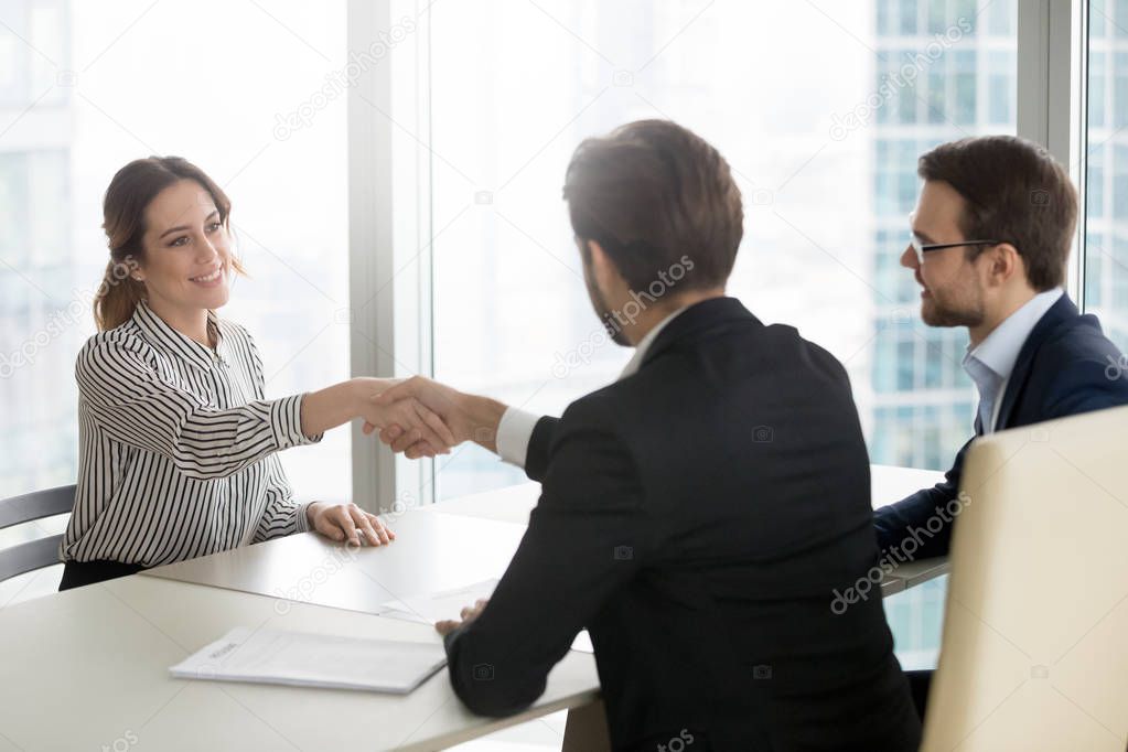 Confident female job applicant shaking hand of hr recruiting manager