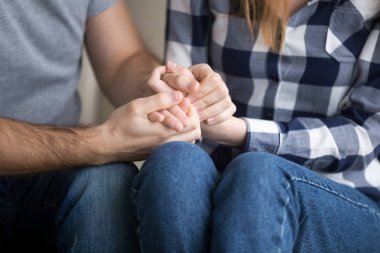 Married couple holding hands giving psychological support, close up view clipart