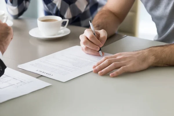 Un couple familial signe un contrat hypothécaire avec un agent immobilier lors d'une réunion bancaire — Photo