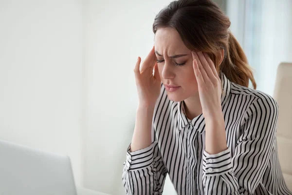 Cansada mujer de negocios estresada sintiendo fuerte dolor de cabeza masaje templos en la oficina —  Fotos de Stock