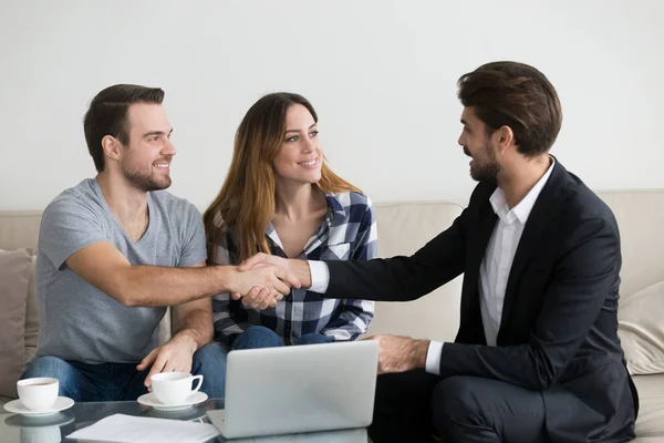 Gelukkige familie paar huurders huurders handshaking makelaar verhuurder tijdens bijeenkomst — Stockfoto