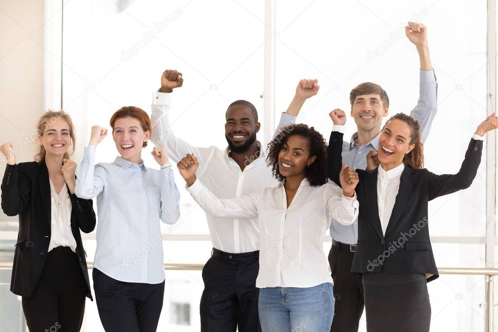 Happy diverse employees celebrating victory and success at work