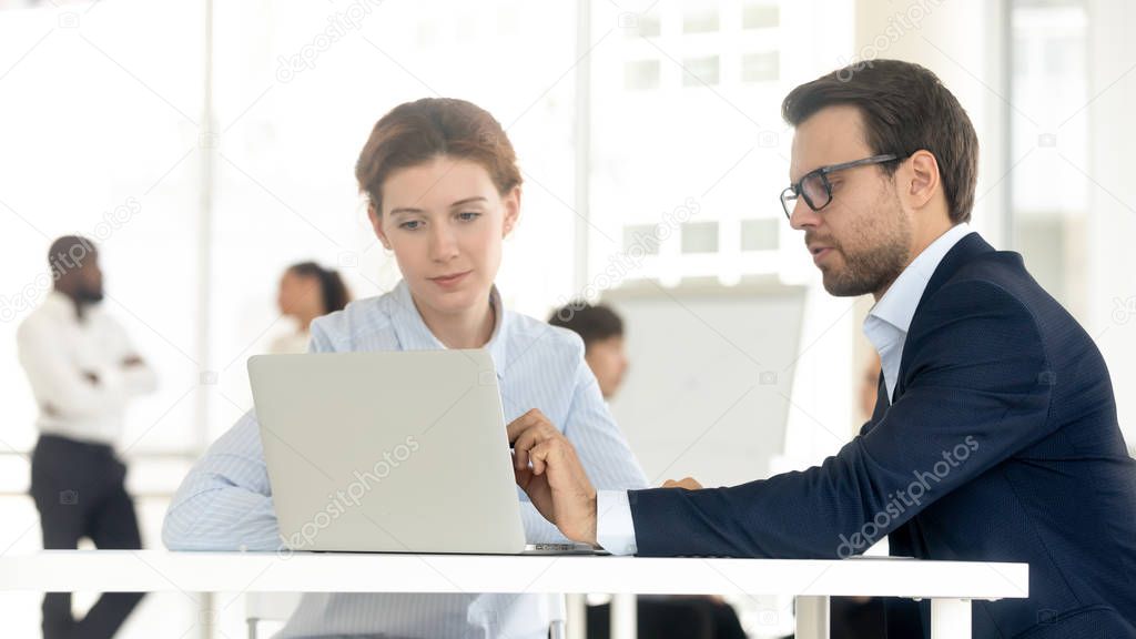 Businessman and businesswoman working together use computer in coworking office