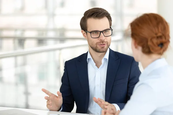 Handsome smiling male office worker talking with female colleague — Stock Photo, Image