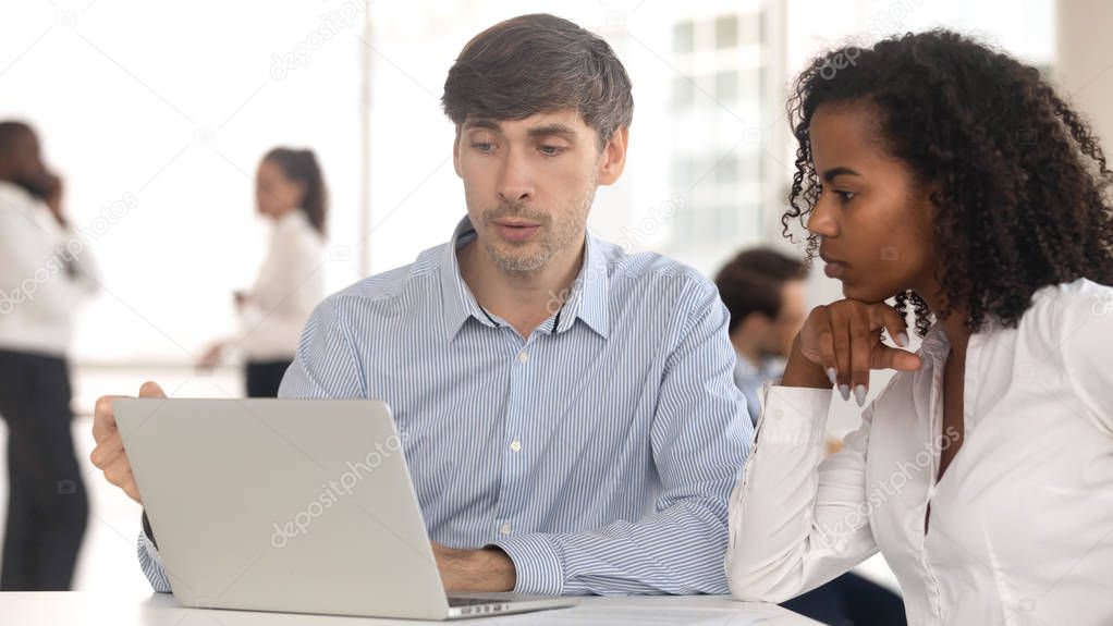 Manager giving consultation to female client sitting at coworking space