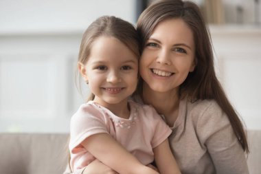 Güzel genç anne ve küçük kızı kameraya bakarak yapıştırma