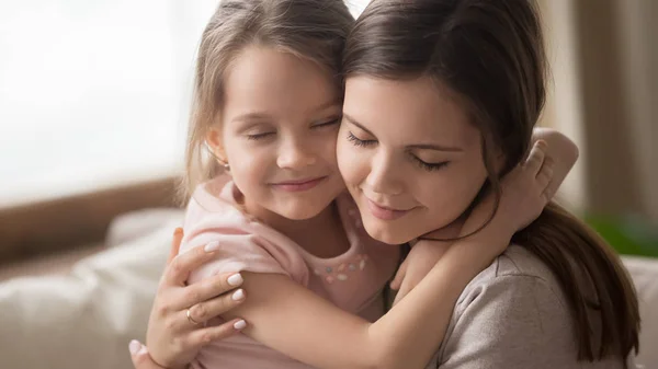 Прихильна сім'я мати обіймає маленьку доньку, яка відчуває любовний зв'язок — стокове фото