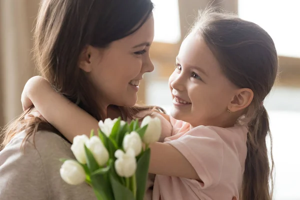 Gelukkig kind dochter omhelst moeder tulpen op Moederdag ontvangen — Stockfoto