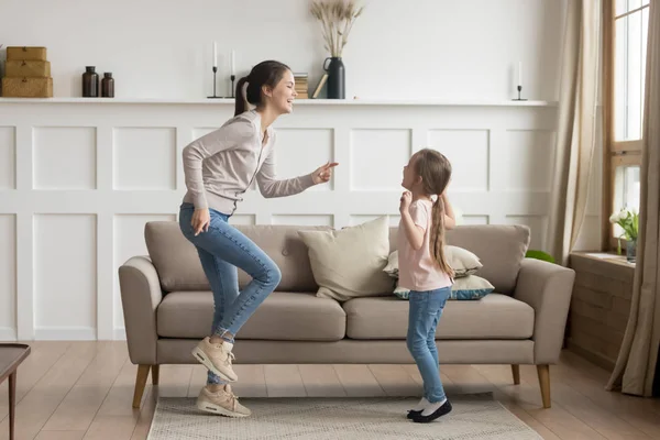 Gelukkig moeder en kind dochtertje lachen thuis dansen — Stockfoto