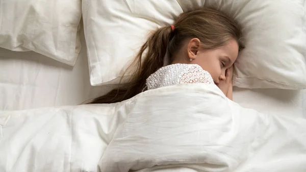 Gadis kecil yang cantik tidur sendirian di tempat tidur yang nyaman, pemandangan yang indah — Stok Foto